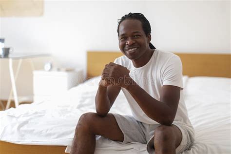 black man sitting on bed